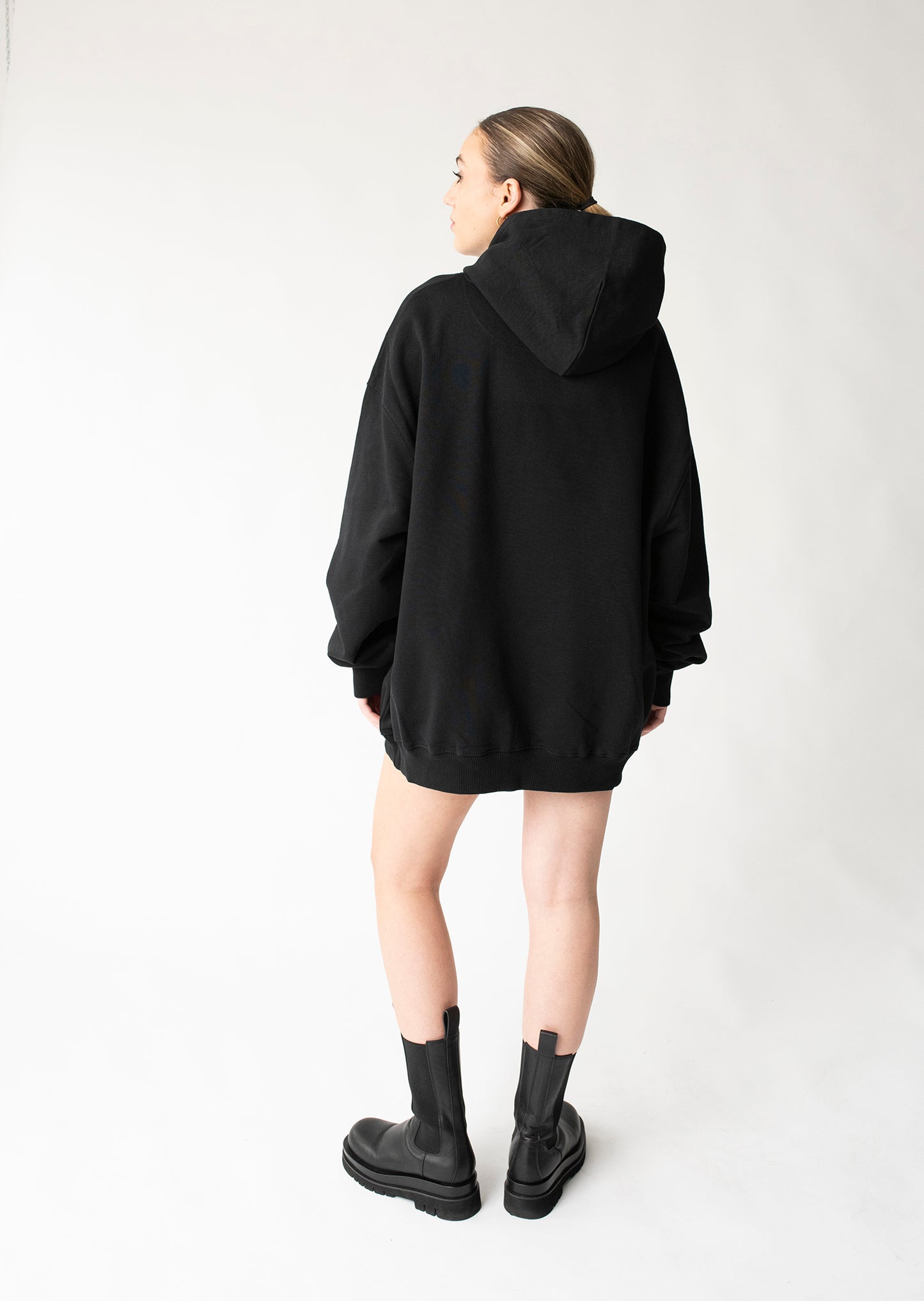 Rückansicht Unisex-Fit Hoodie im kastigen Schnitt und monochromen Logo Stick umlaufend