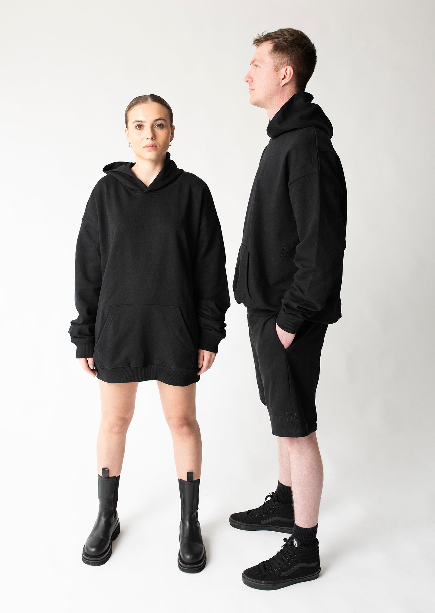 Lässiger Unisex-Fit Hoodie im kastigen Schnitt, Schwarz mit Känguru-Tasche, filigranem monochromen Logo Stick umlaufend