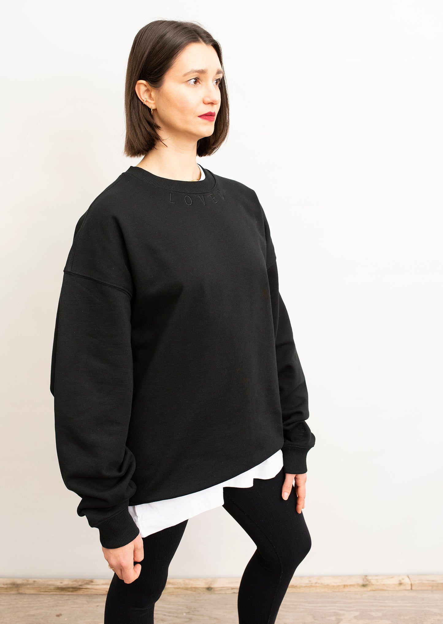 seitliche Ansicht Crewneck Sweater Unisex in Schwarz mit schwarzem Loved-Stick
